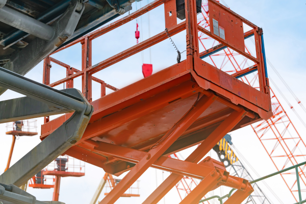 An orange boom lift at sunset.